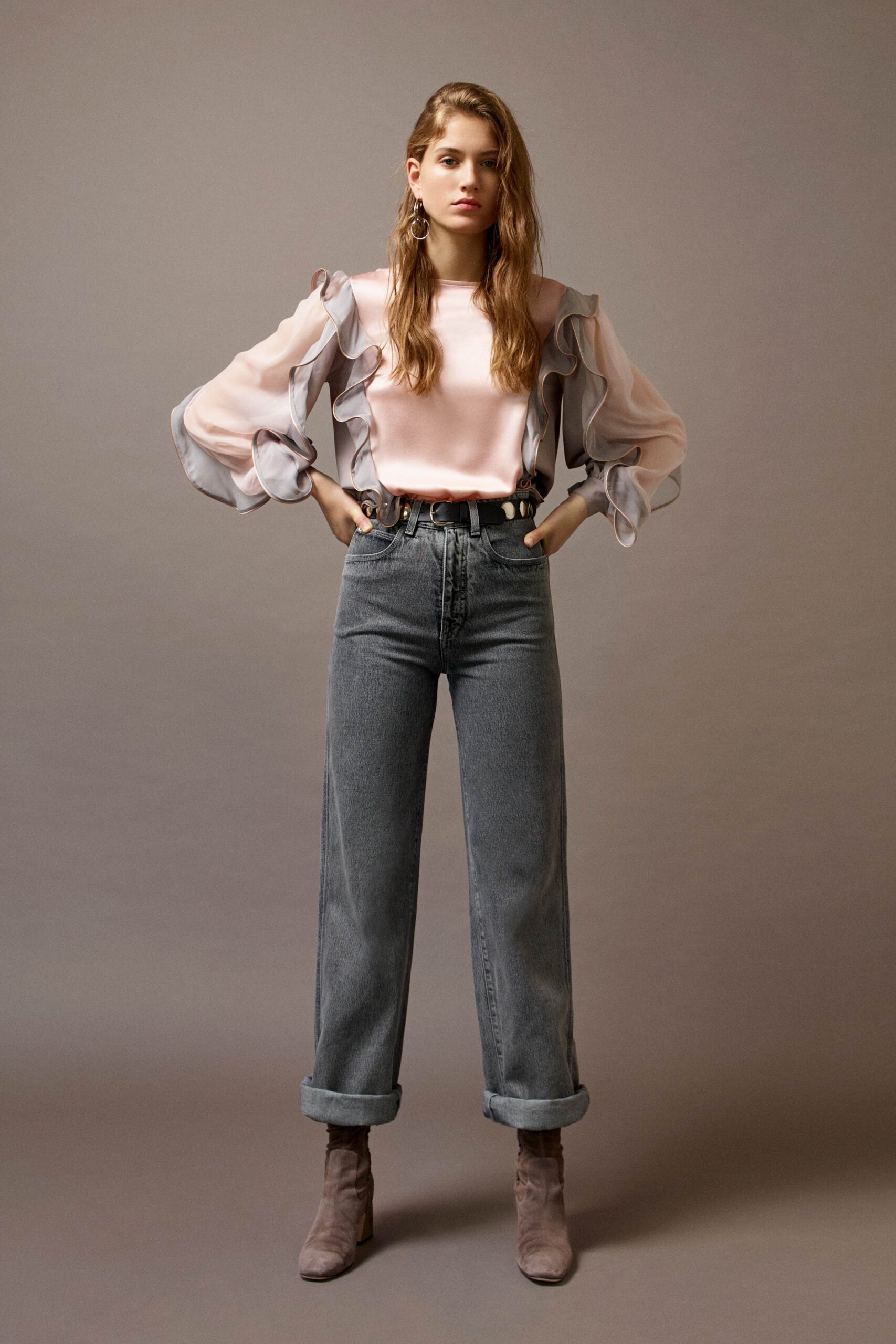 pink ruffled top with gray jeans