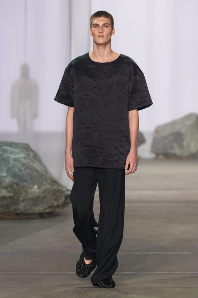A relaxed black cotton top with a printed design paired with matching black pants.