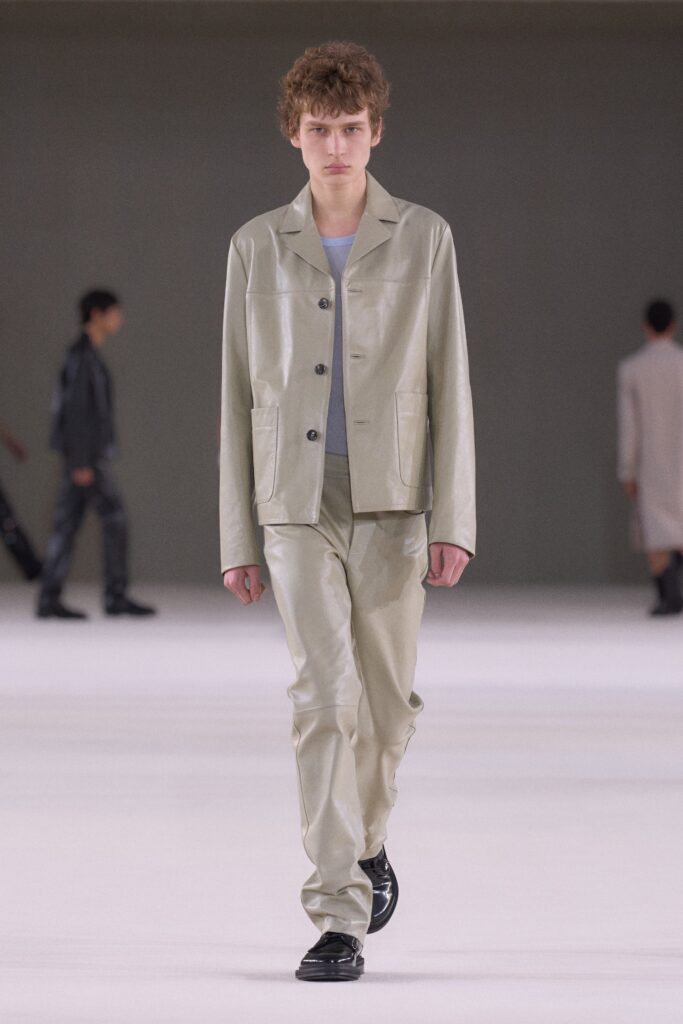 A fitted beige leather suit with a collared long-sleeve jacket and straight-leg pants.