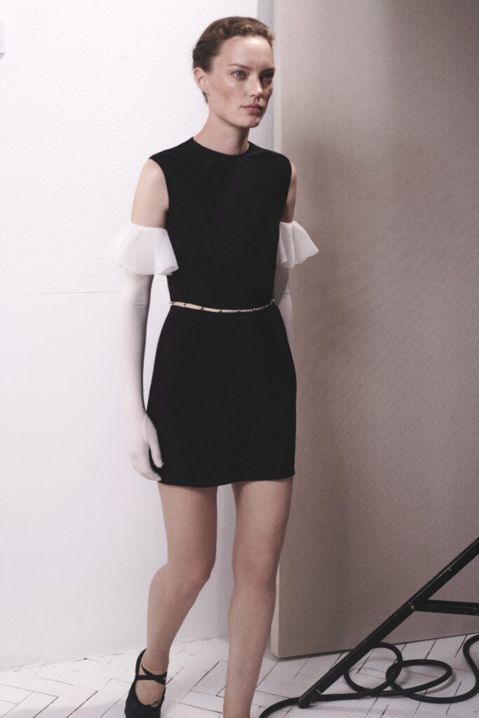 A fitted black and white dress with short sleeves and an asymmetric design detail.