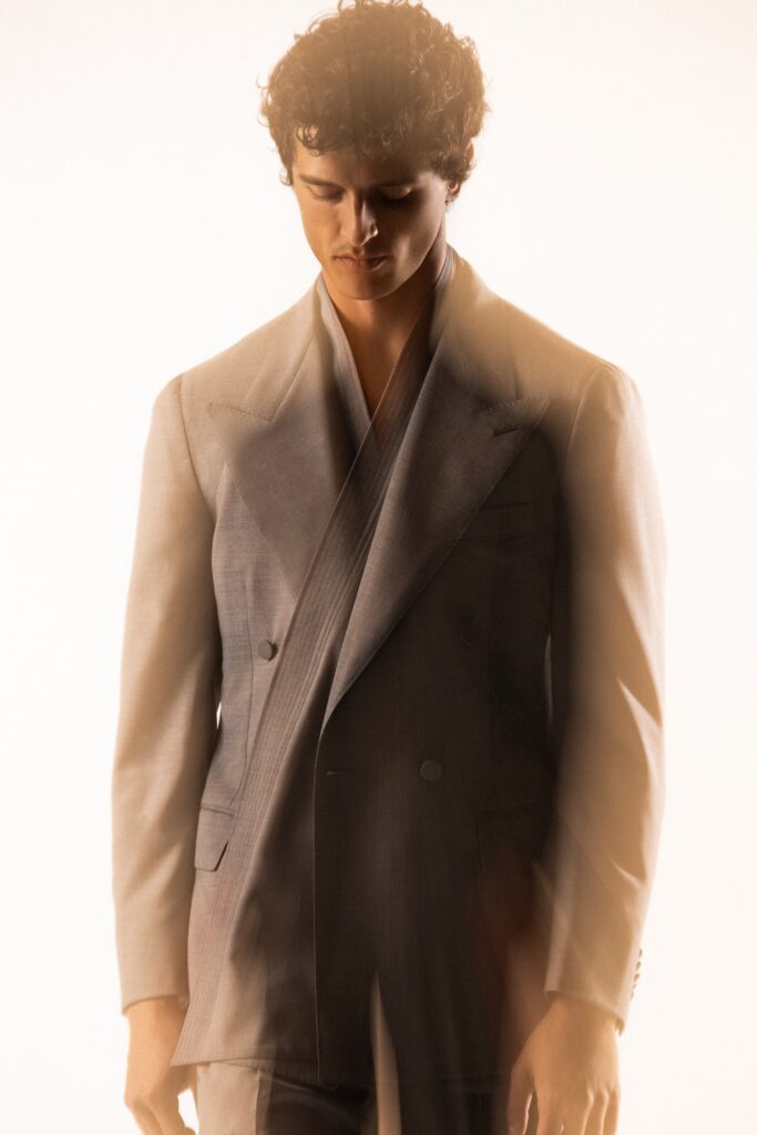 A tailored gray wool suit with long sleeves and a collared design, featuring buttoned details.