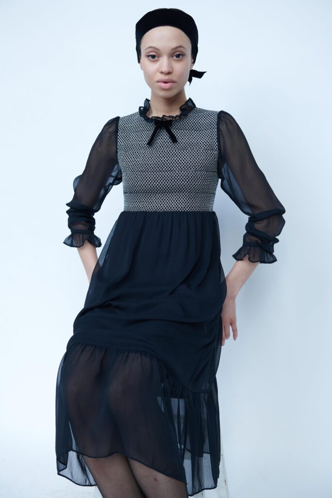 A relaxed black silk dress with long sleeves and a tiered design.