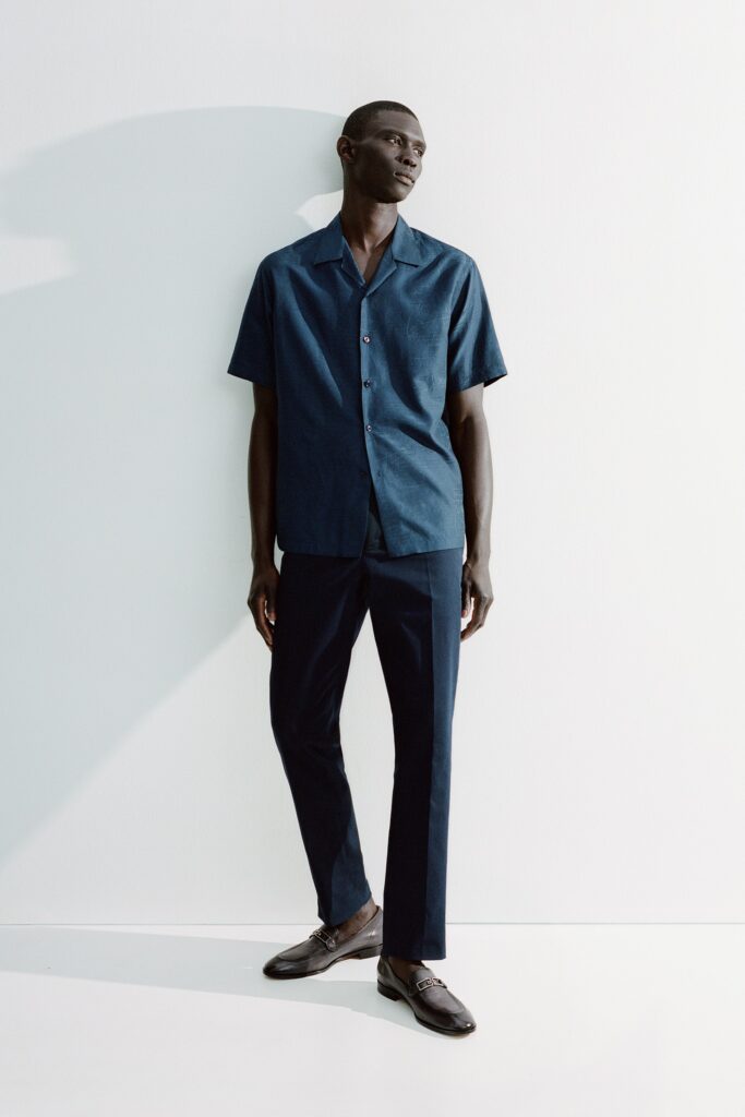 A fitted blue cotton short-sleeve shirt paired with navy straight-leg pants.