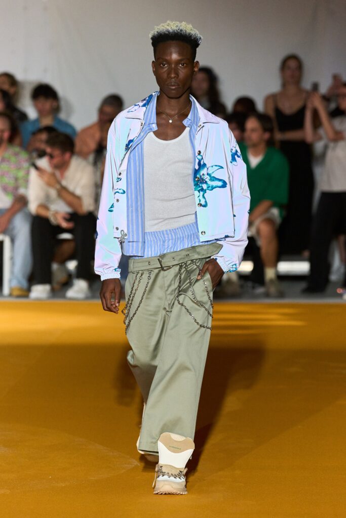 A relaxed fit blue printed jacket paired with loose-fitting pants for a casual runway look.