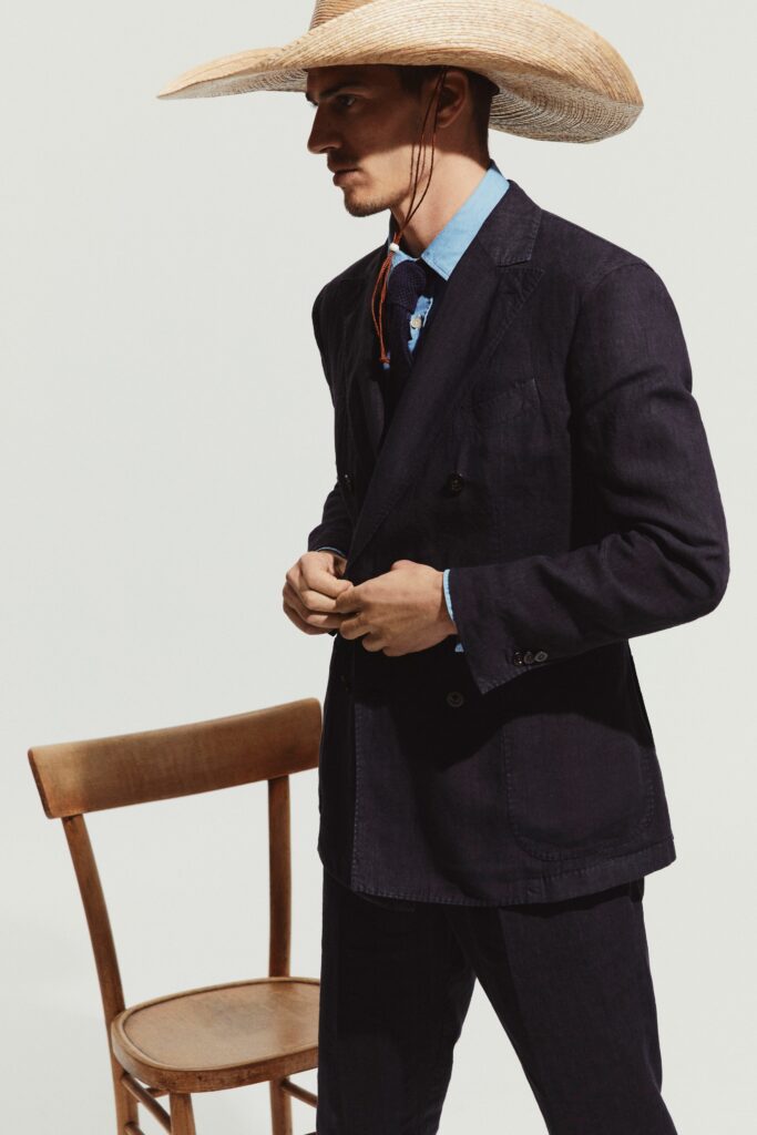 A tailored navy suit paired with a blue collared shirt, featuring button details.