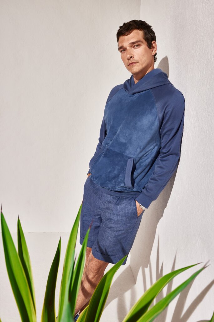 A relaxed blue cotton hoodie with long sleeves paired with matching shorts.