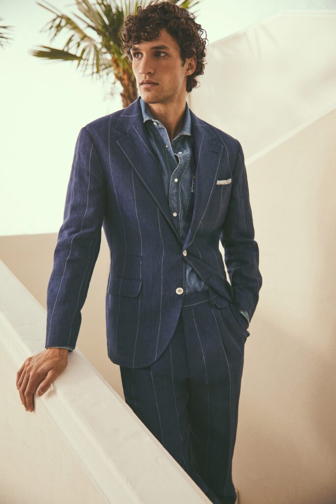 A tailored blue striped suit with a long-sleeve collared shirt underneath.