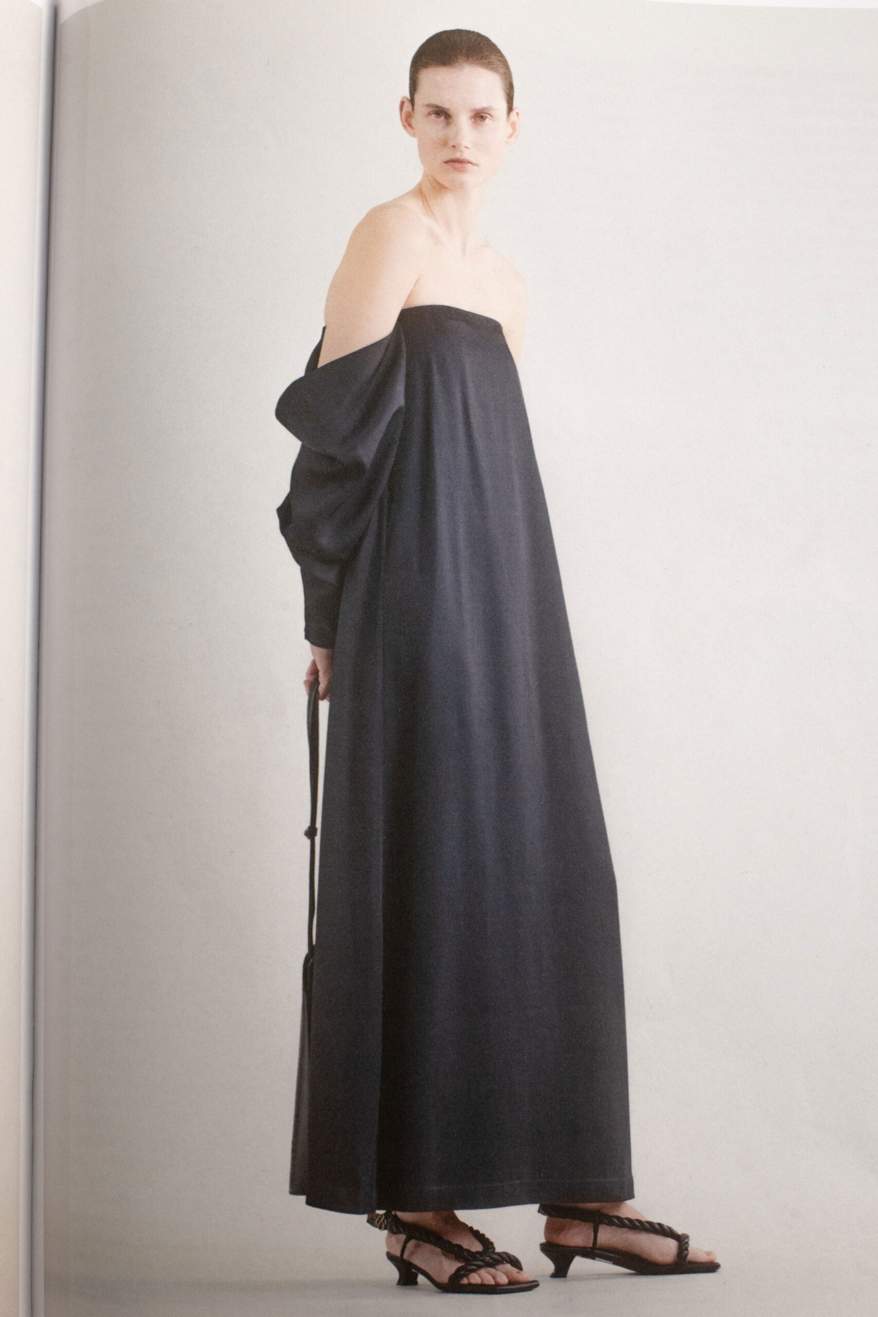 A relaxed black off-shoulder dress with a maxi silhouette, perfect for a chic look.