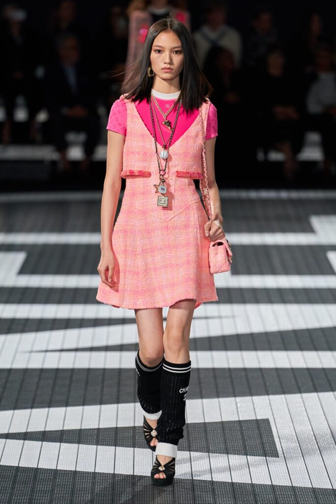 A fitted pink cotton sleeveless dress with a collared top and layered design.