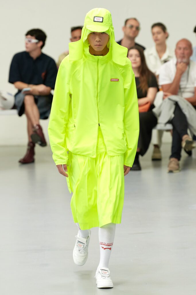 A relaxed yellow cotton jacket with a hood paired with an asymmetric skirt.