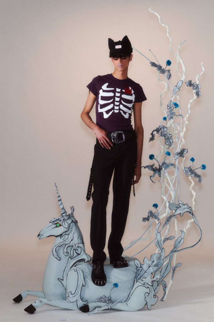 A fitted black and purple printed t-shirt paired with black pants.