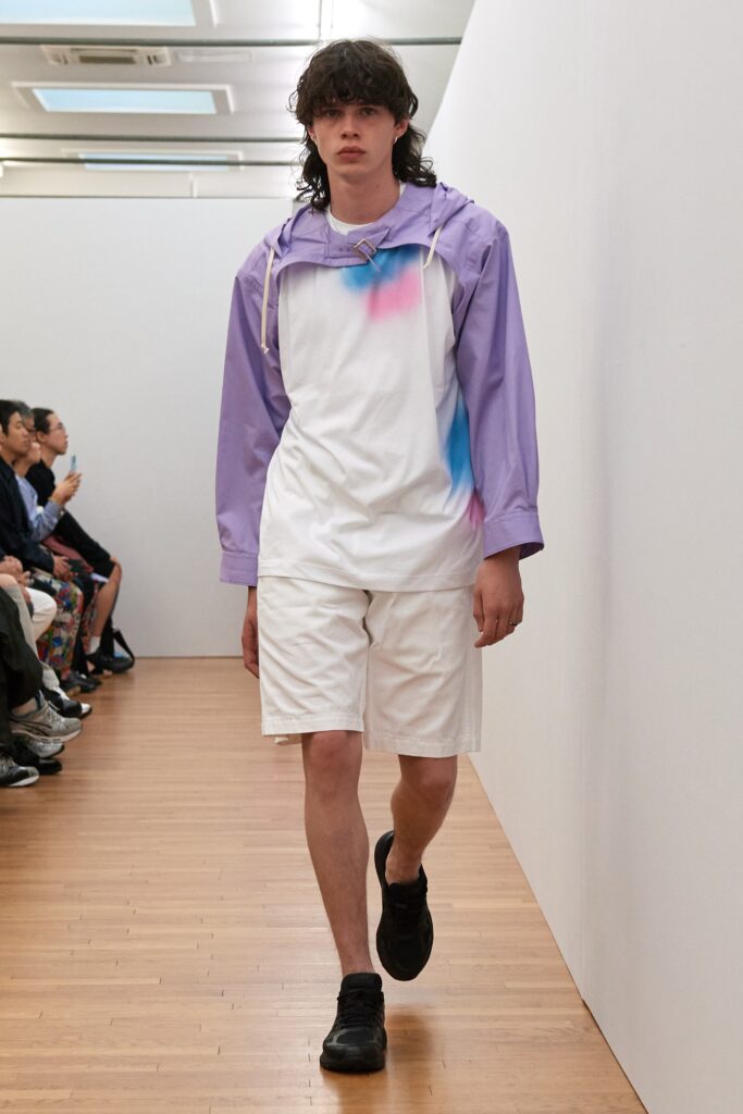 A relaxed-fit purple hooded shirt paired with white shorts featuring a color-blocked design.