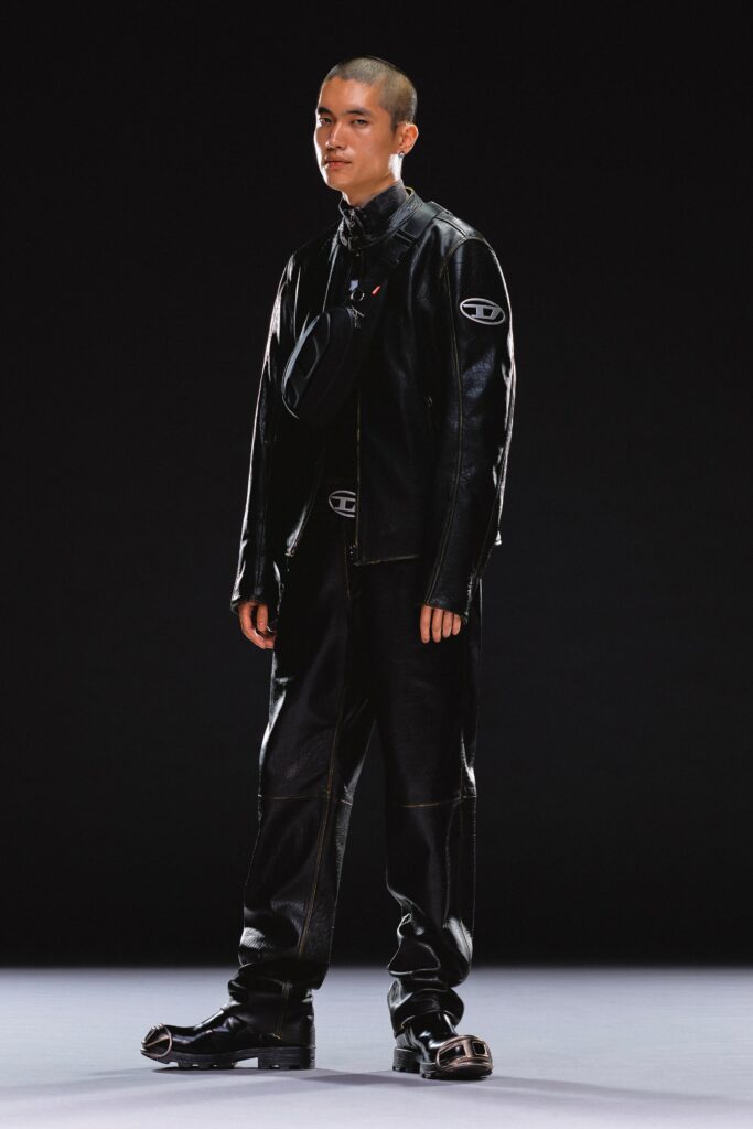 A fitted black leather jacket with long sleeves and collared design paired with matching pants.
