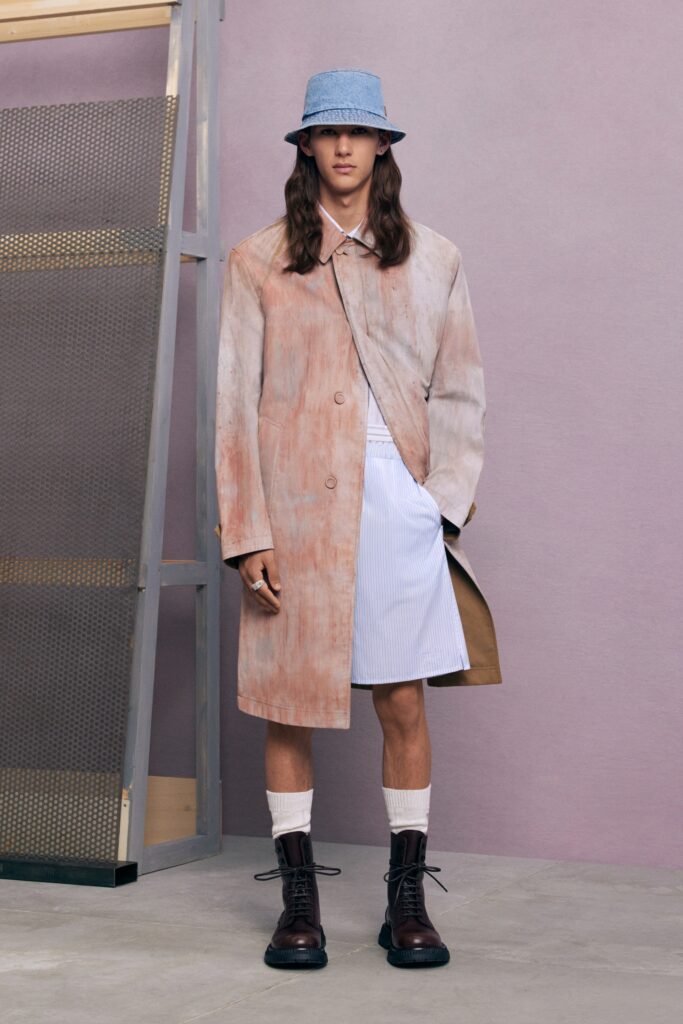 An oversized beige coat paired with a blue denim skirt, creating a unique fashion statement.