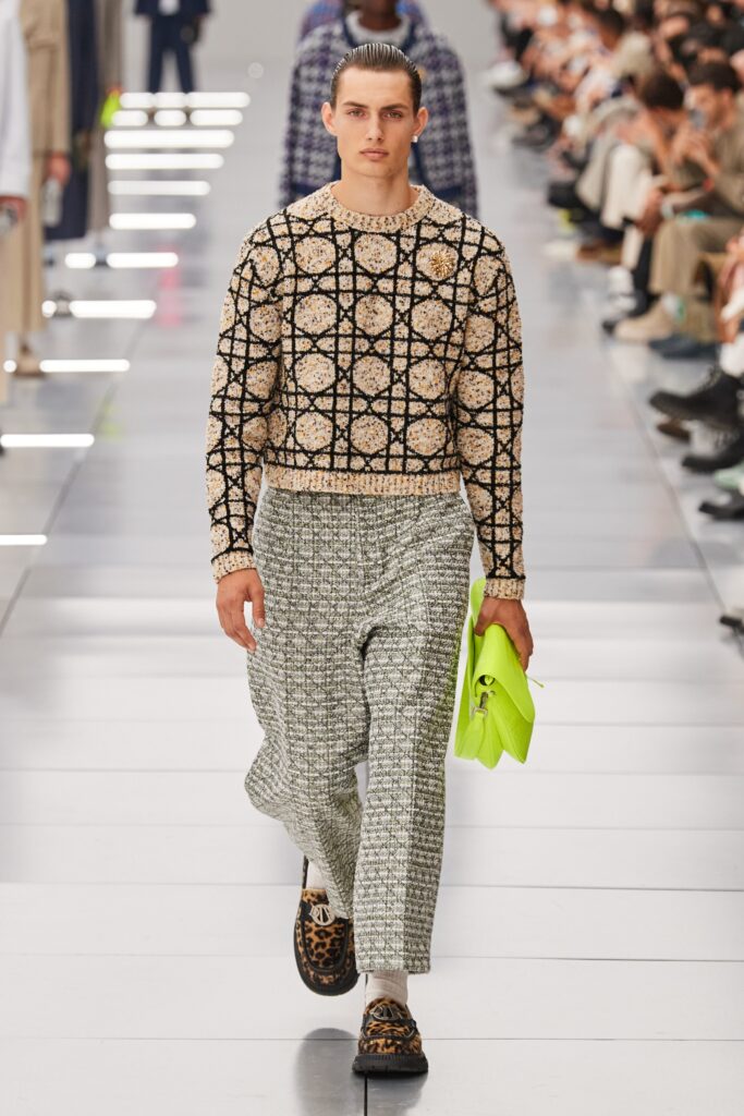 A relaxed beige printed long-sleeve sweater paired with wide-leg gray pants.