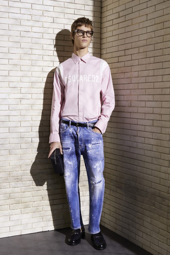 A relaxed pink long-sleeve collared shirt paired with high-waisted distressed denim jeans.