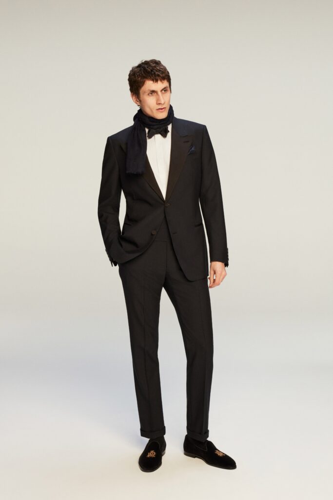 A fitted black cotton suit with a collared long-sleeve shirt and buttoned details.