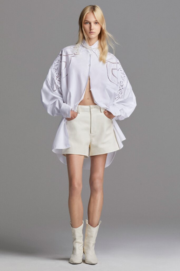 A relaxed white shirt with long sleeves and embroidery, paired with tailored shorts.