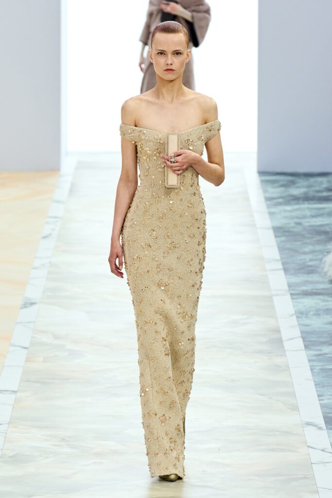 A fitted beige silk strapless gown adorned with intricate beading for a glamorous look.