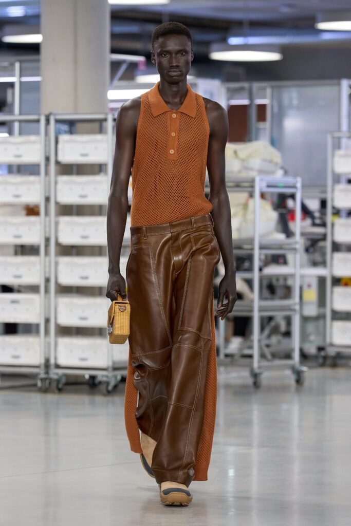 A relaxed orange cotton sleeveless top paired with layered wide-leg brown leather pants.