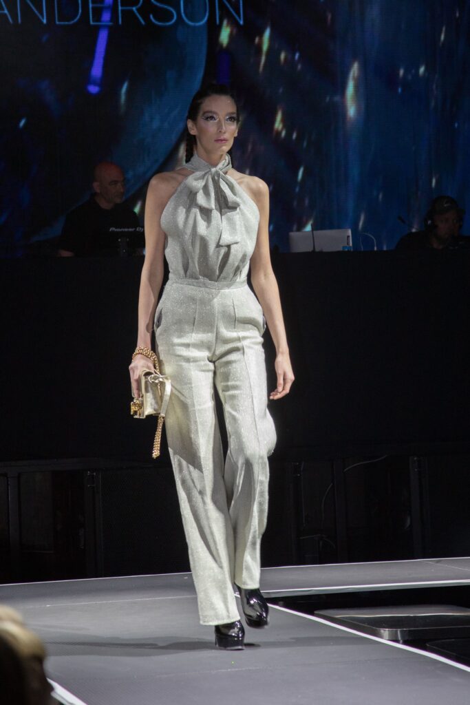 A fitted gray silk jumpsuit with a sleeveless design and pleated detailing.