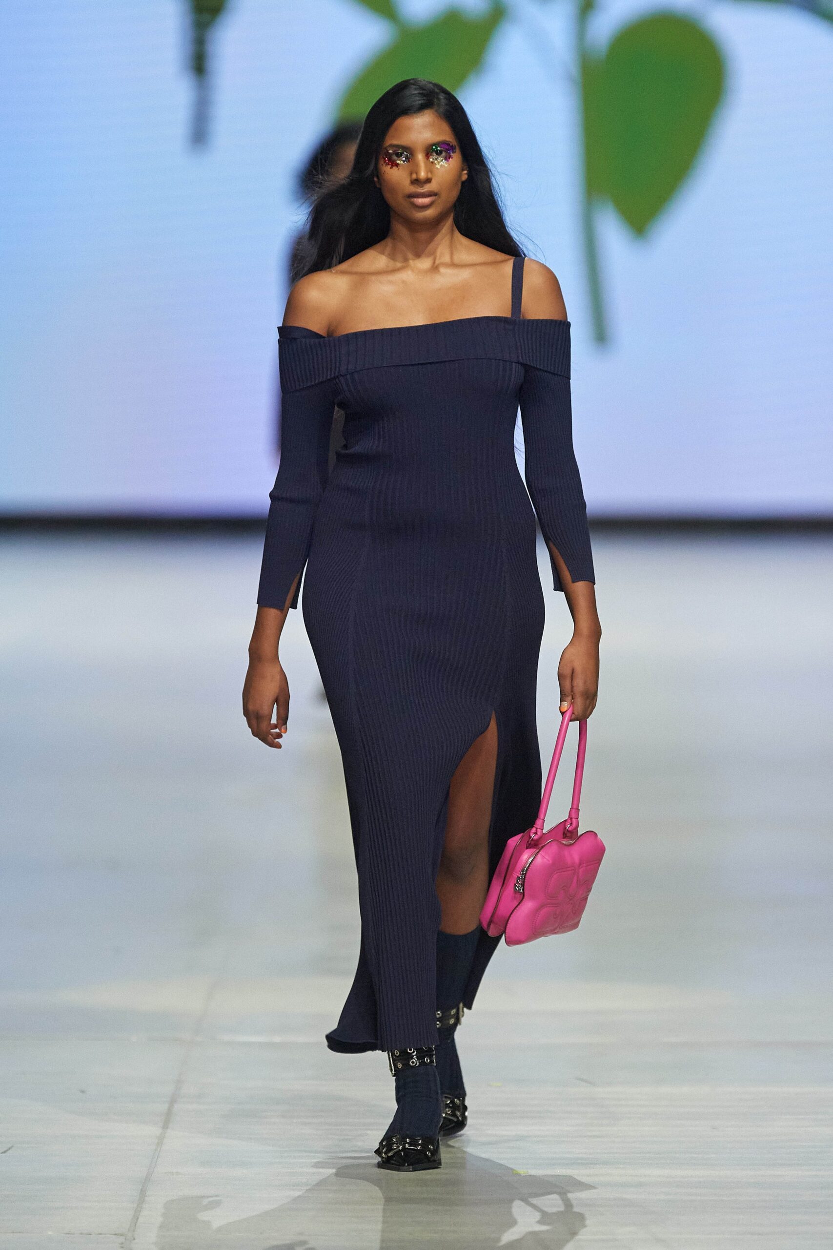 A fitted navy off-shoulder dress with long sleeves and a stylish slit.