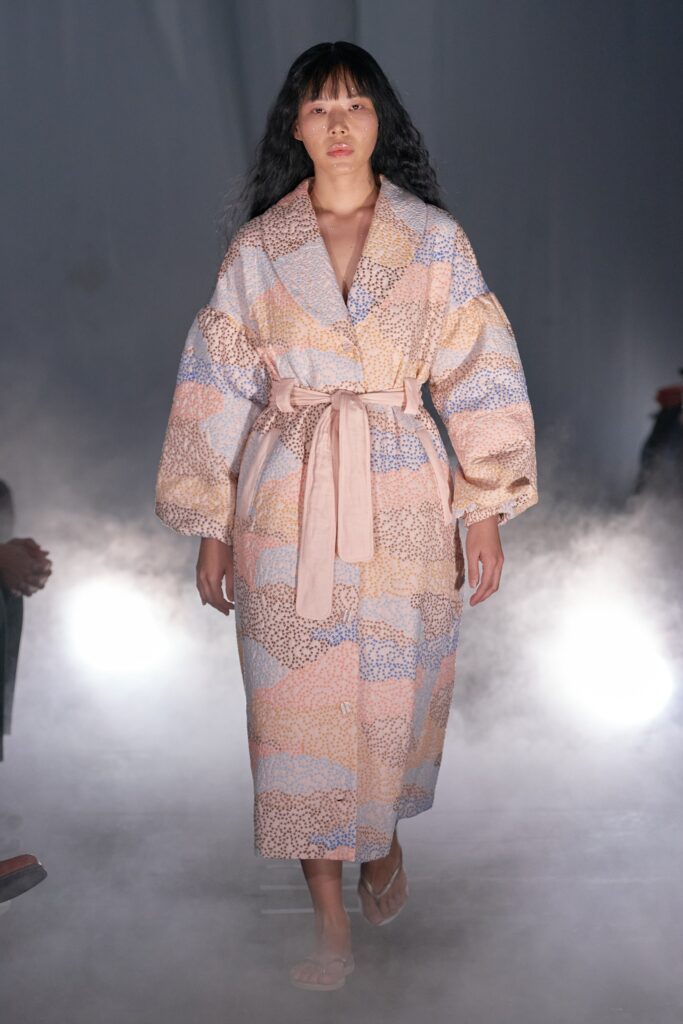 A relaxed coat with long sleeves and a collared design featuring a colorful printed pattern.