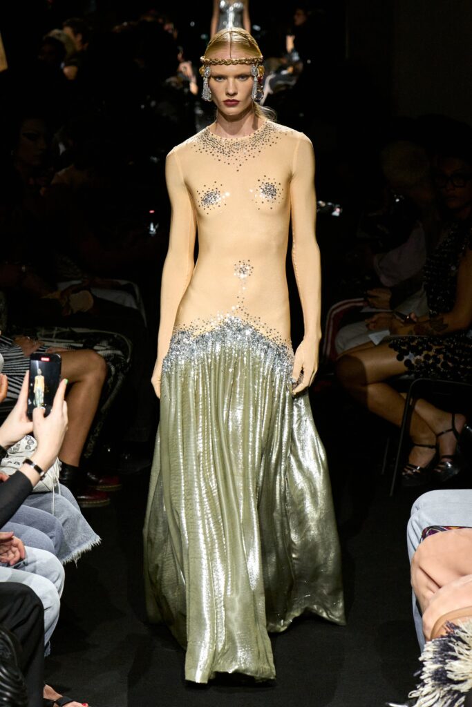 A fitted gold sequined dress with a high neckline and flared silhouette.