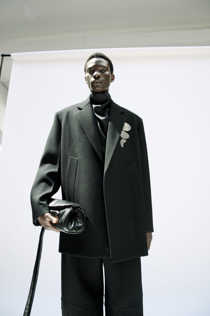 An oversized black wool jacket with a collared design and asymmetric detail.