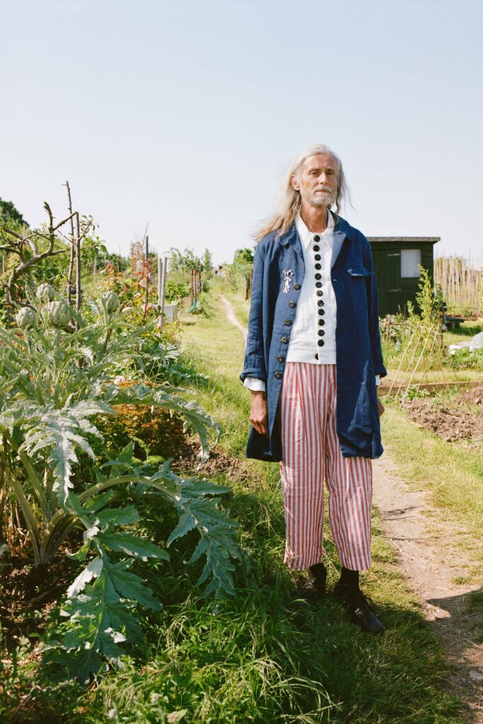 A relaxed blue coat paired with white and red striped pants, featuring a collared neckline.