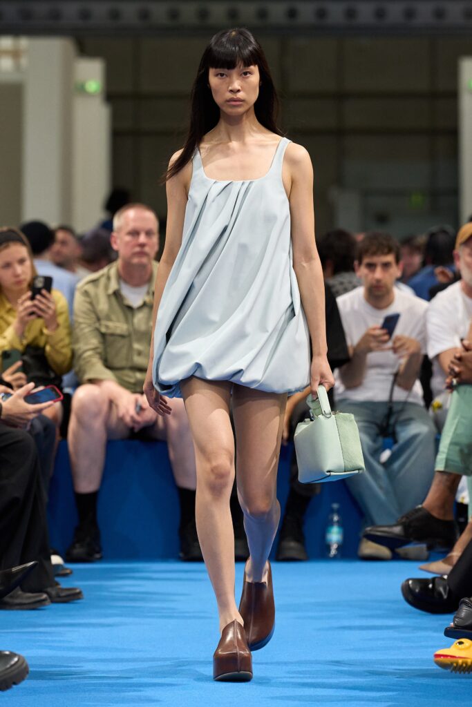 A relaxed blue cotton sleeveless dress with a draped design.