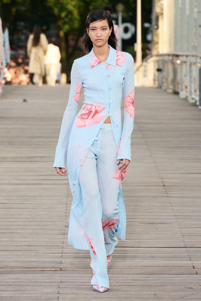 A fitted blue silk dress with long sleeves and a collared neckline, paired with flared printed pants.
