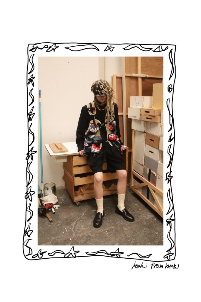 An oversized multicolor jacket paired with black shorts, creating a unique streetwear look.