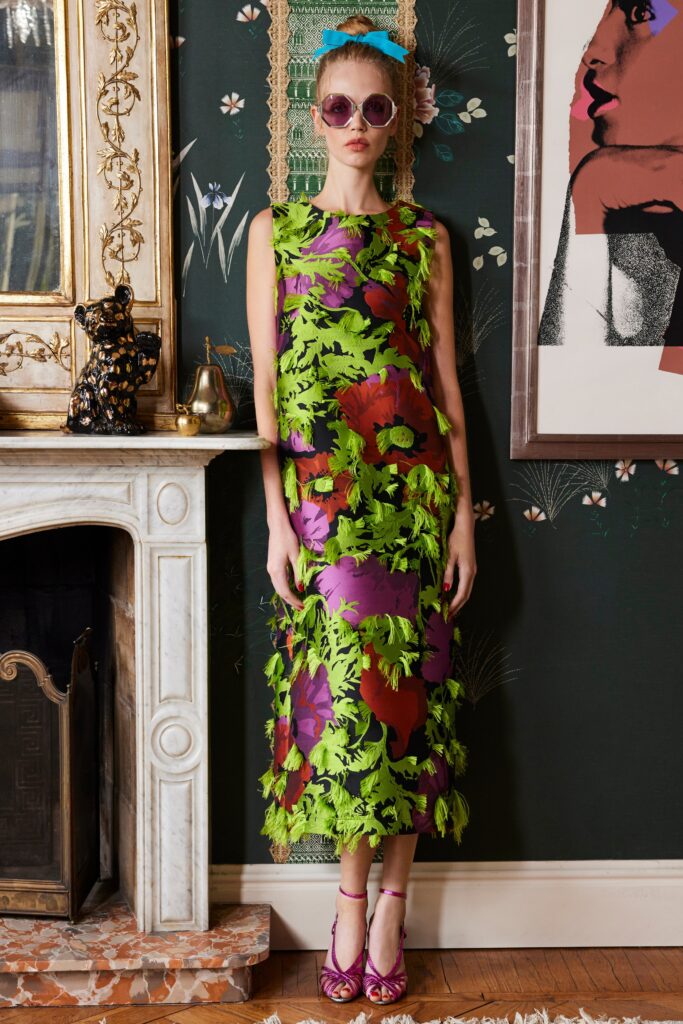 A fitted floral silk sleeveless dress with a high neckline and layered design.