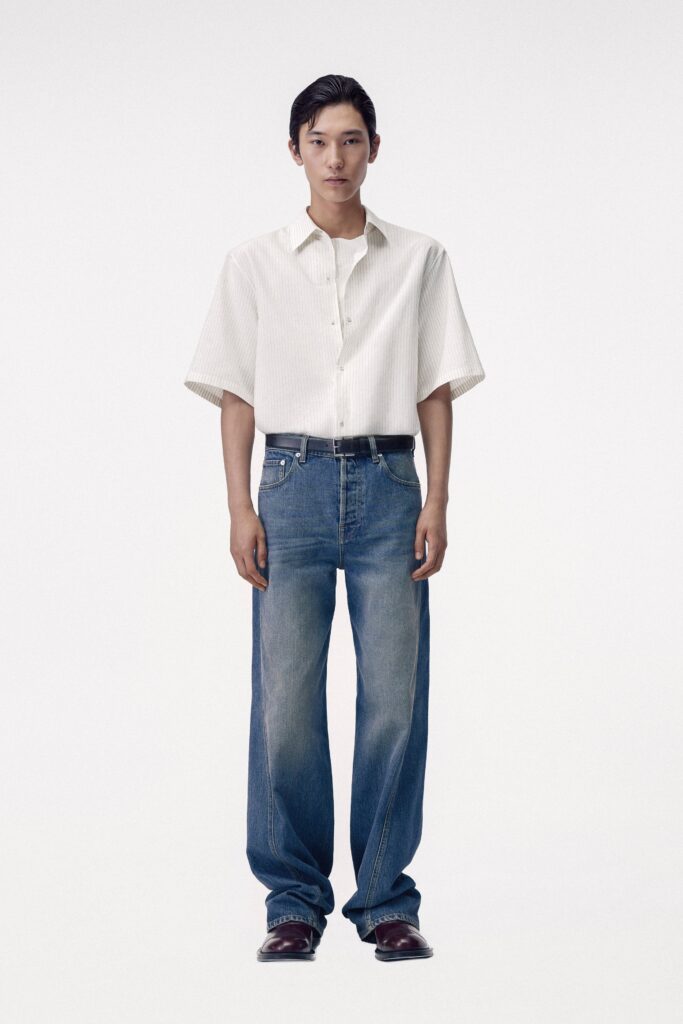 A relaxed white short-sleeve collared shirt paired with straight-leg blue denim jeans.