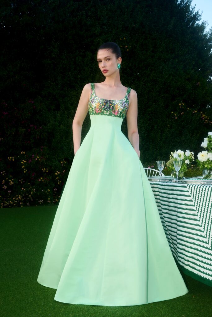 A fitted green silk sleeveless dress with a V-neckline and A-line silhouette.
