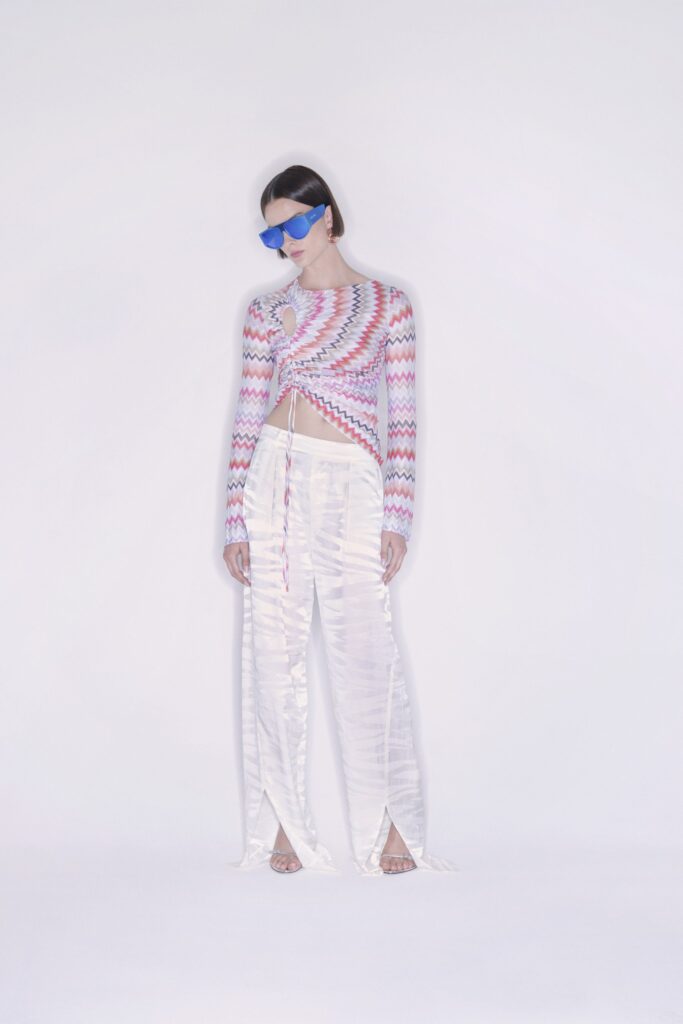 A relaxed pink striped silk top with long sleeves paired with white silk pants.