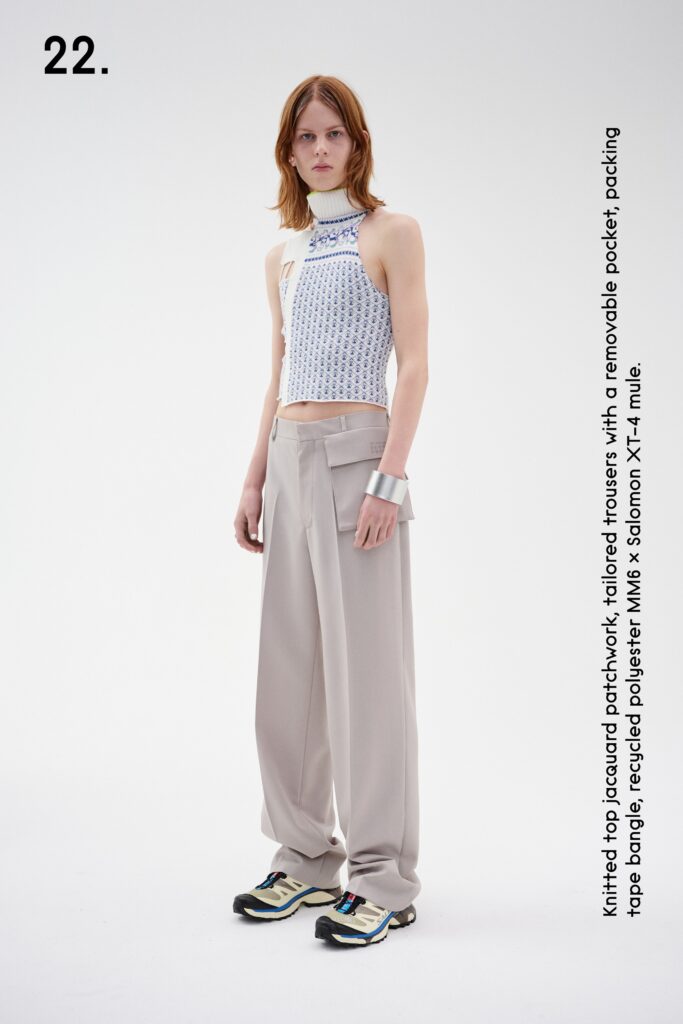 A relaxed white sleeveless top with a printed design paired with beige wide-leg trousers.