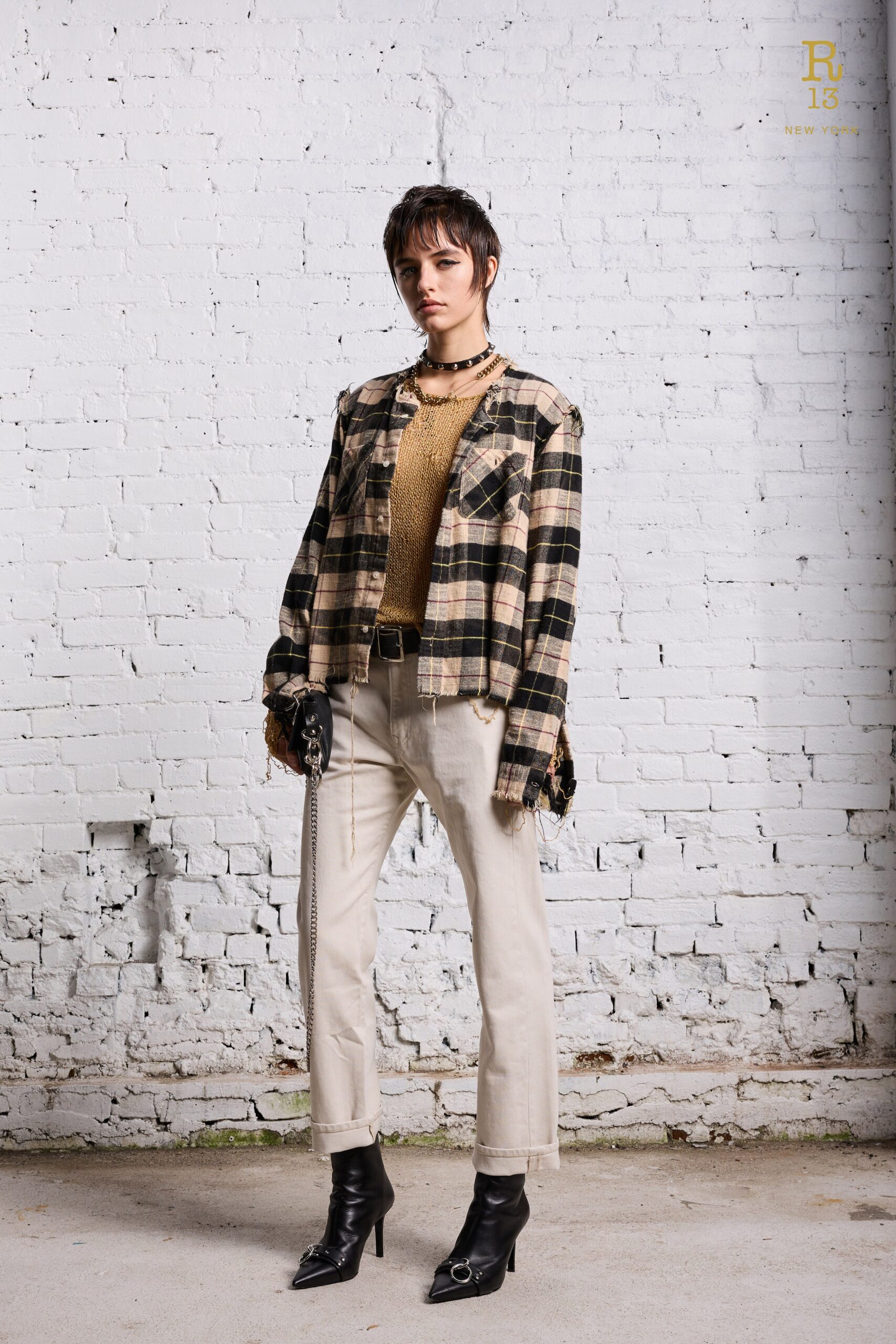 A fitted plaid jacket with long sleeves paired with beige fitted pants.