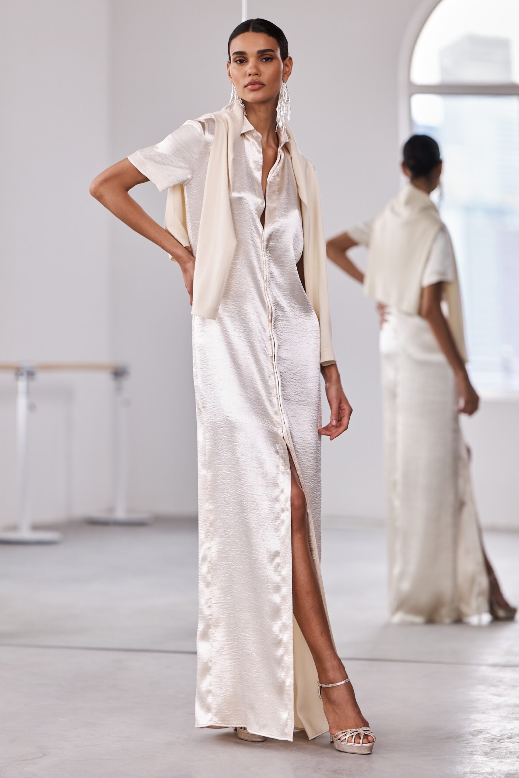 A fitted cream silk dress with short sleeves, a collared neckline, and a side slit.