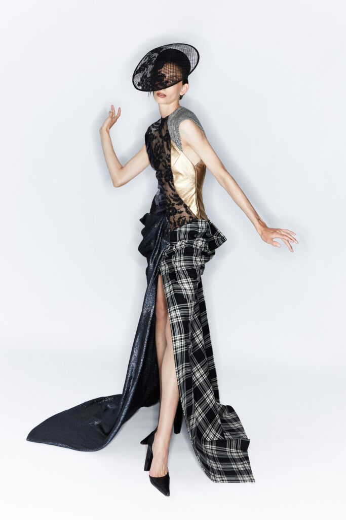 A fitted black and gold sleeveless dress with an asymmetric design and tiered elements.