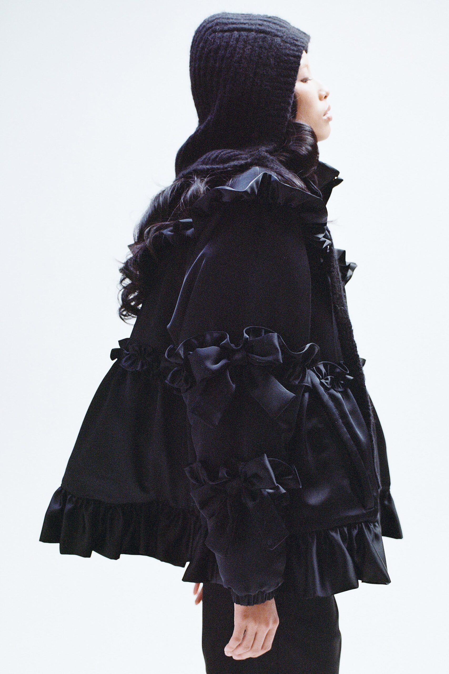 A relaxed black silk jacket with long sleeves and ruffled detailing.