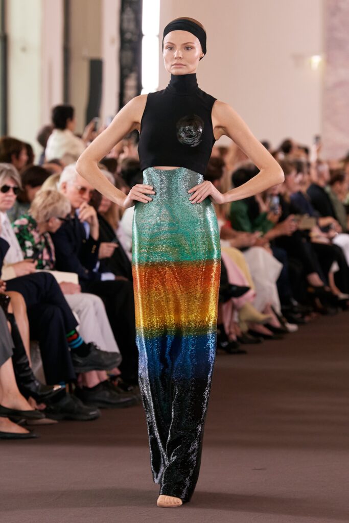 A fitted black dress with a high-neck and layered multicolor design.