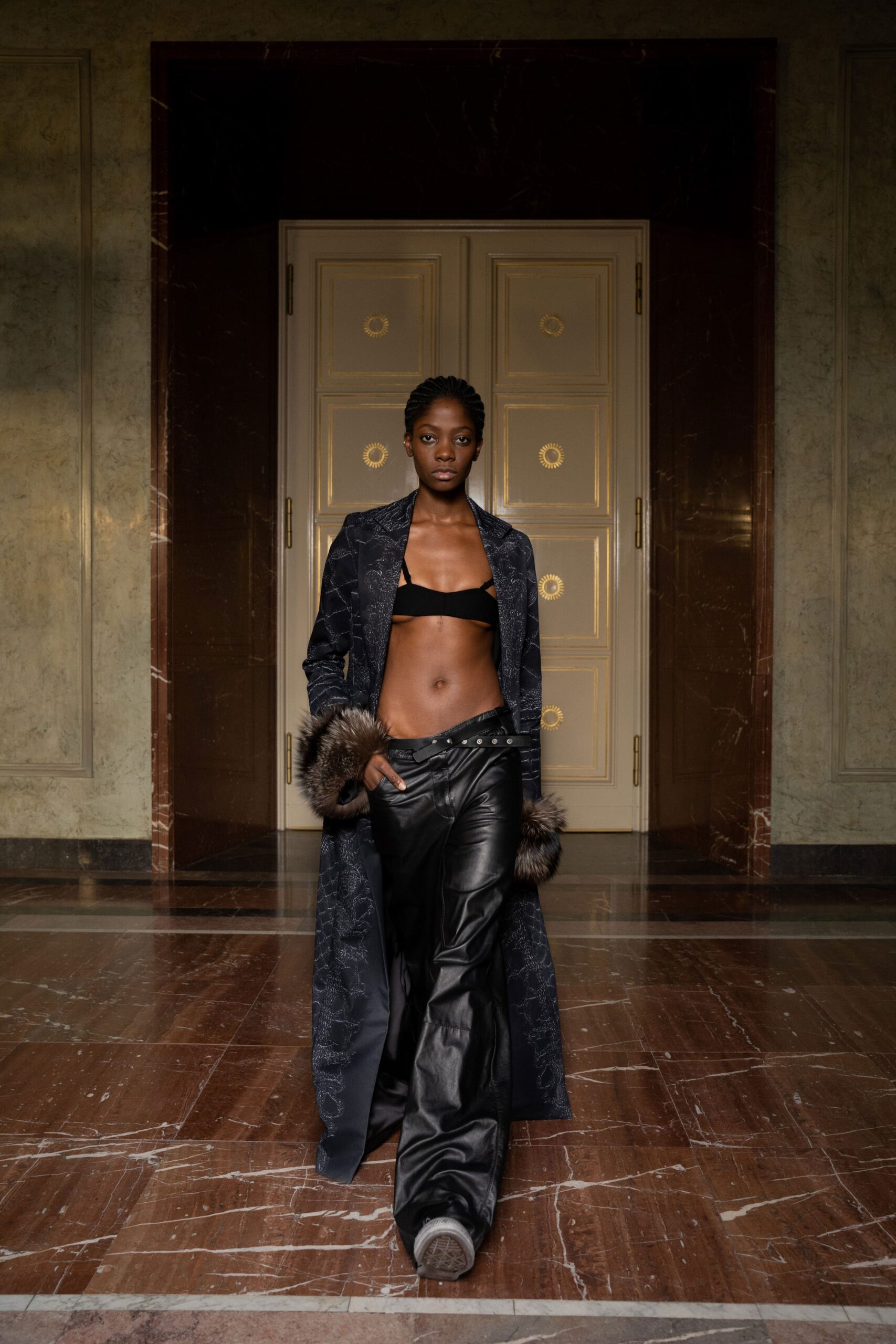 A relaxed black leather coat with long sleeves and layered pants.