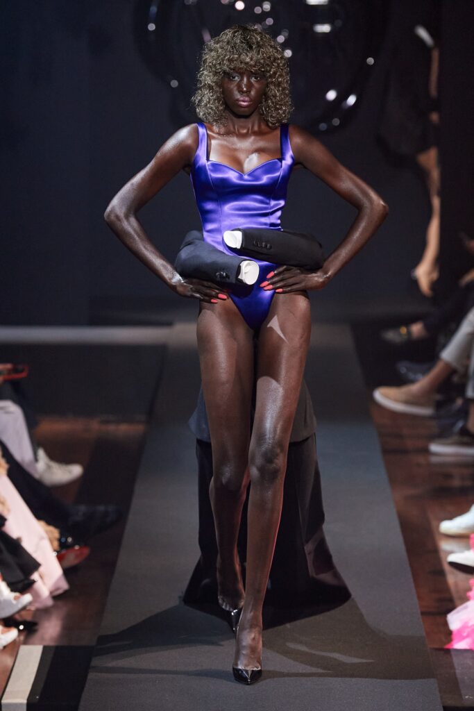 A fitted blue silk swimsuit with a V-neckline and asymmetric design details.