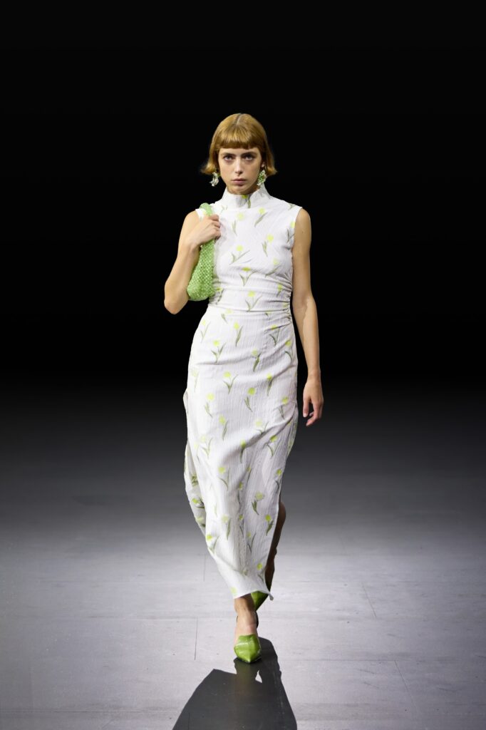A fitted white sleeveless dress adorned with floral patterns, perfect for a stylish summer look.