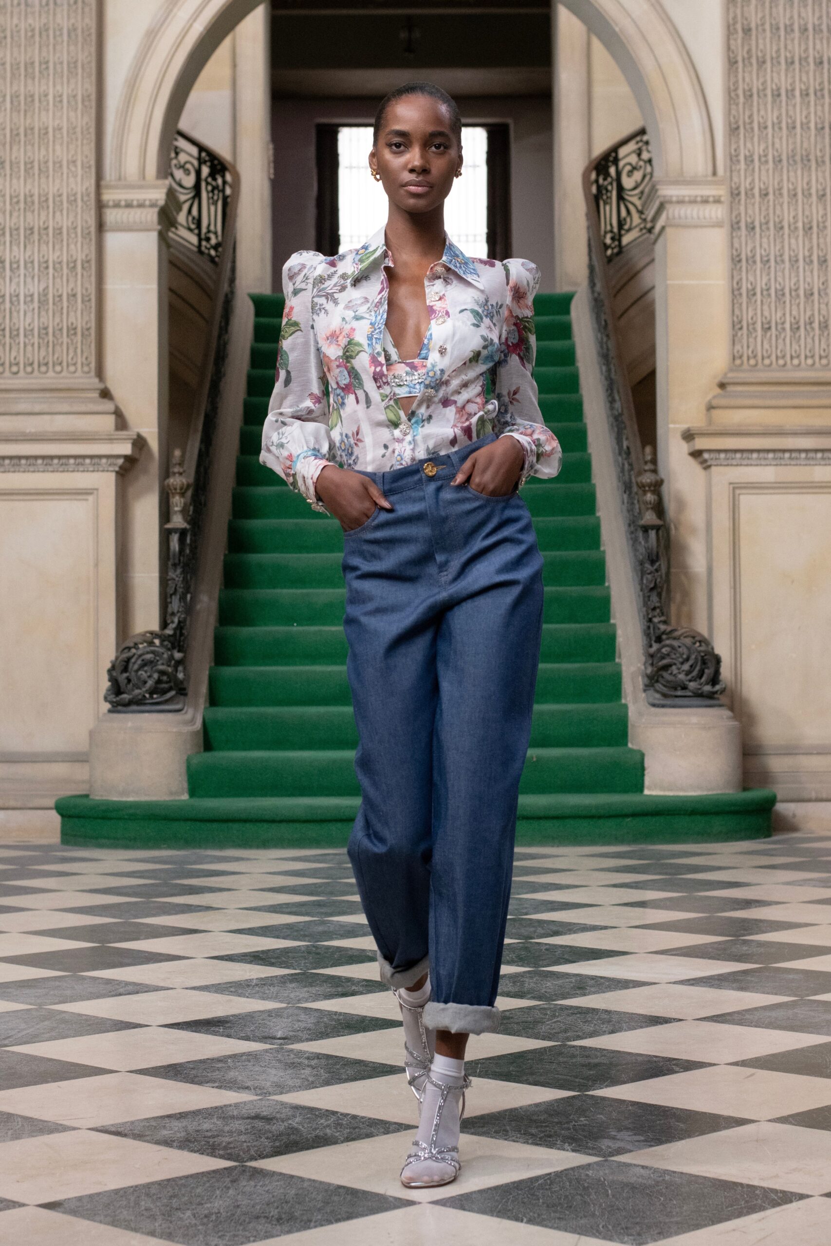A relaxed floral blouse paired with high-waisted blue denim pants for a chic look.