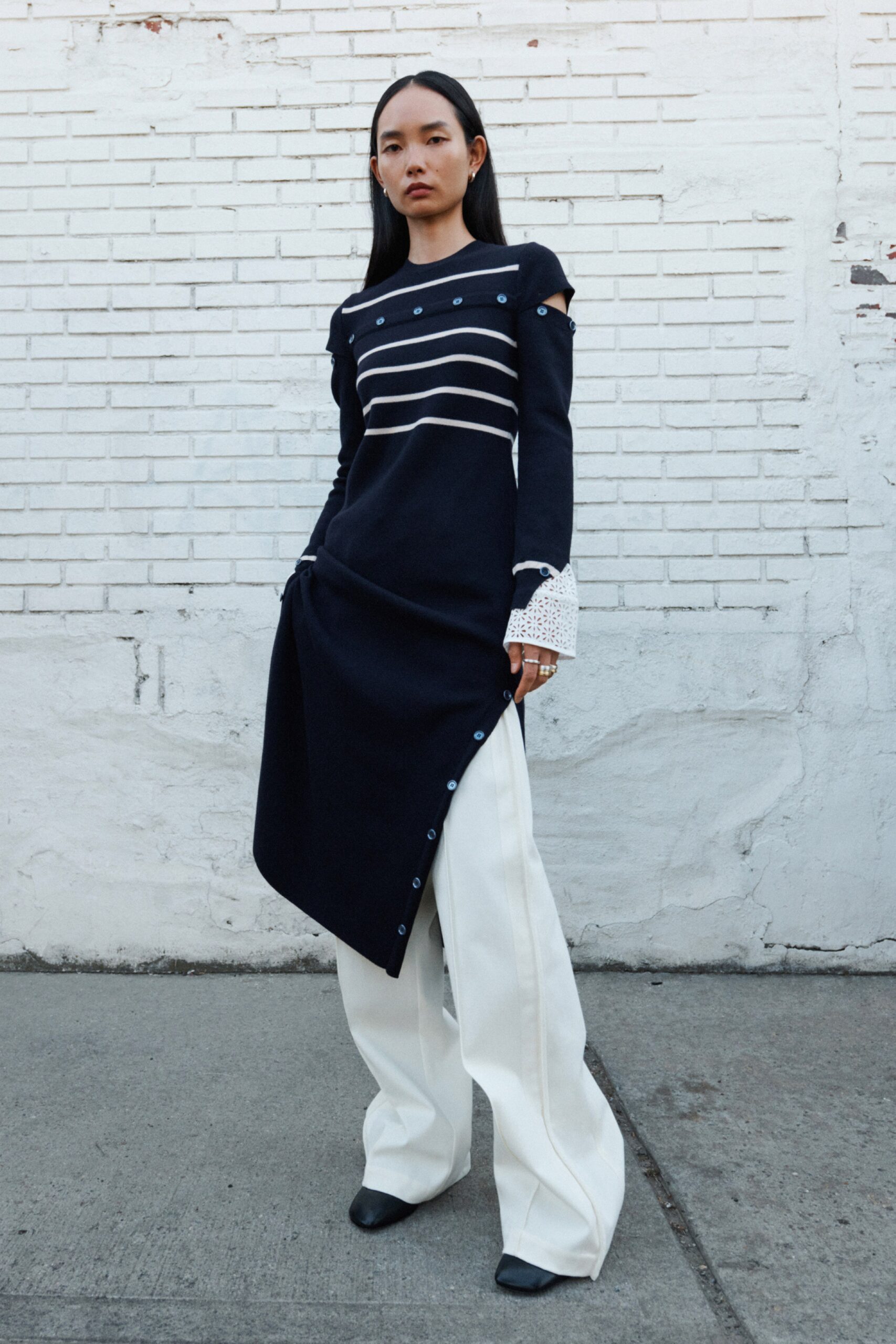 A relaxed black and white striped dress with long sleeves and an asymmetric design.