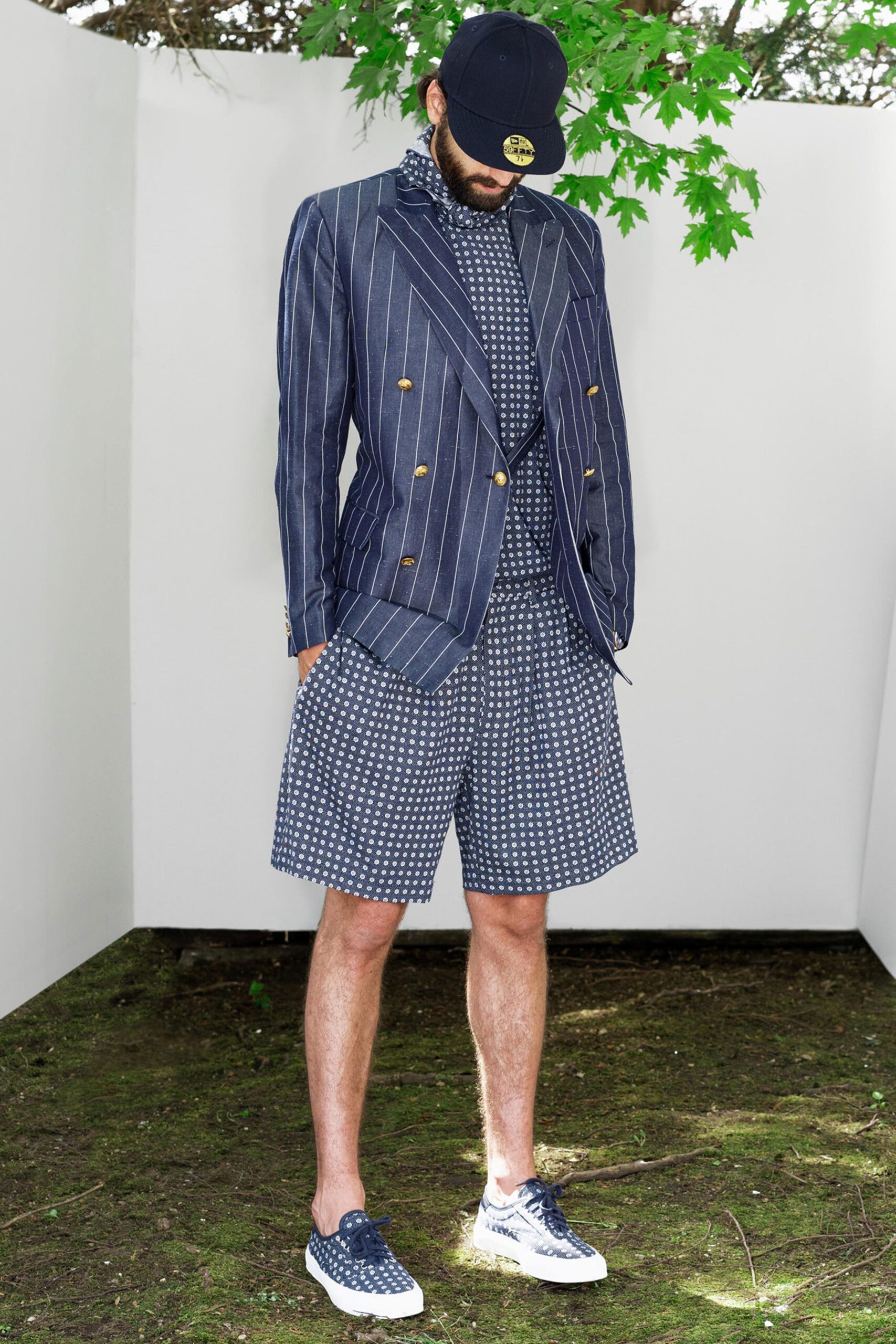 A relaxed-fit navy striped blazer paired with polka-dot shorts, featuring a collared design.