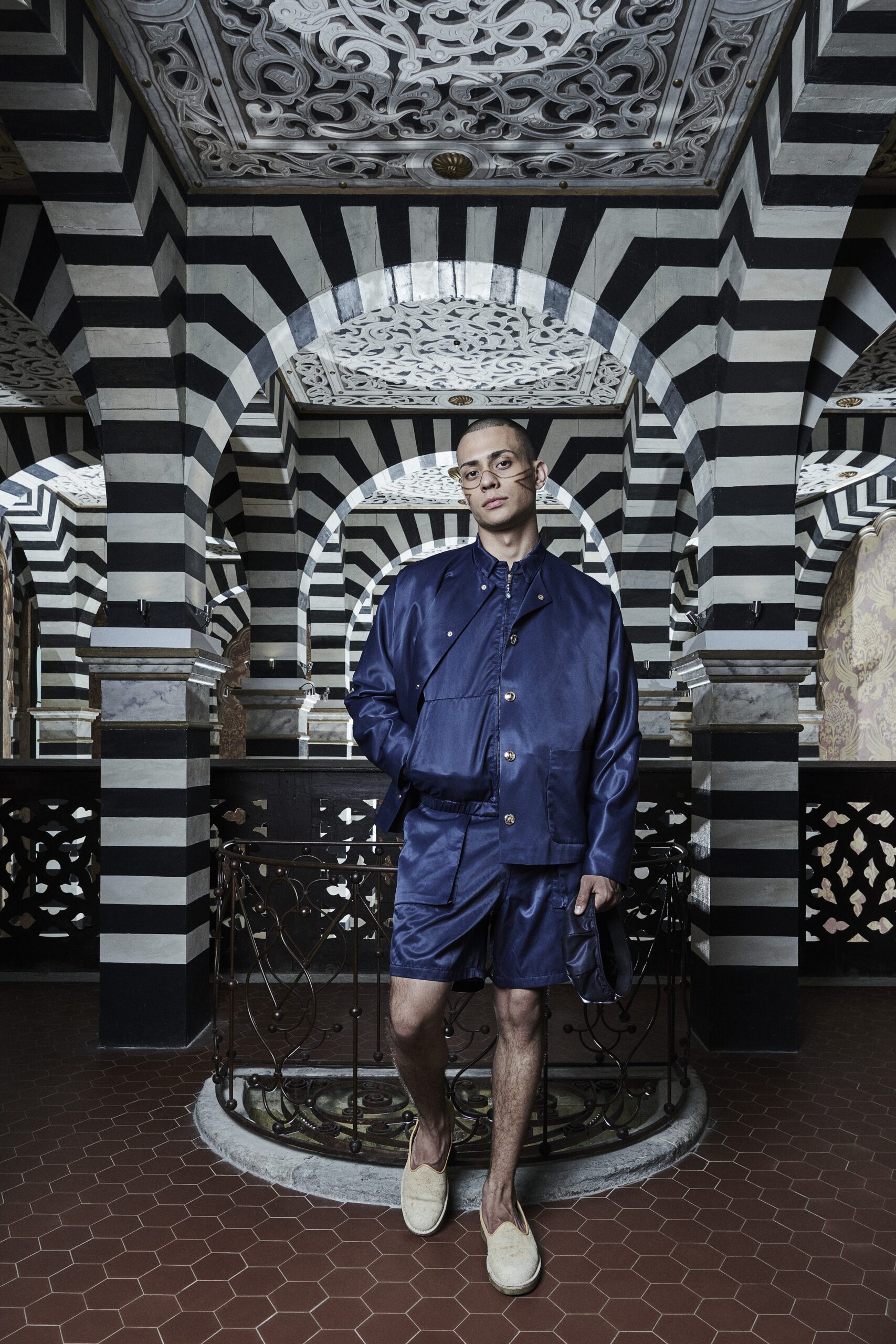 A relaxed blue cotton jacket with short sleeves and matching shorts, featuring a buttoned design.